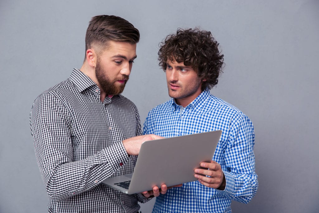 One Guy Shows The Other One Something Interesting On A Laptop
