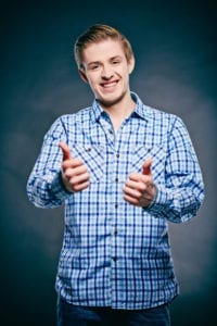 A young guy looking at camera and showing thumbs up