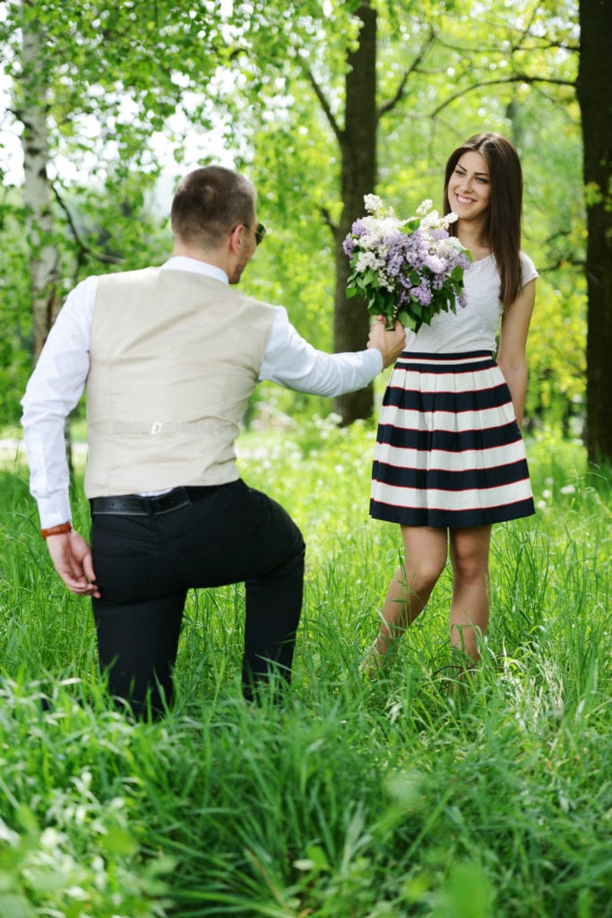 portrait of a man hiding a flowers bouquet behind his back to surprise to a female BFq nN6Ho