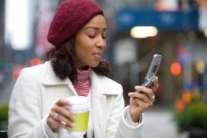 an attractive business woman checking her cell phone in the city she could be text messaging or even browsing the web via wi fi or a 3g connection rYlfUD0Ss