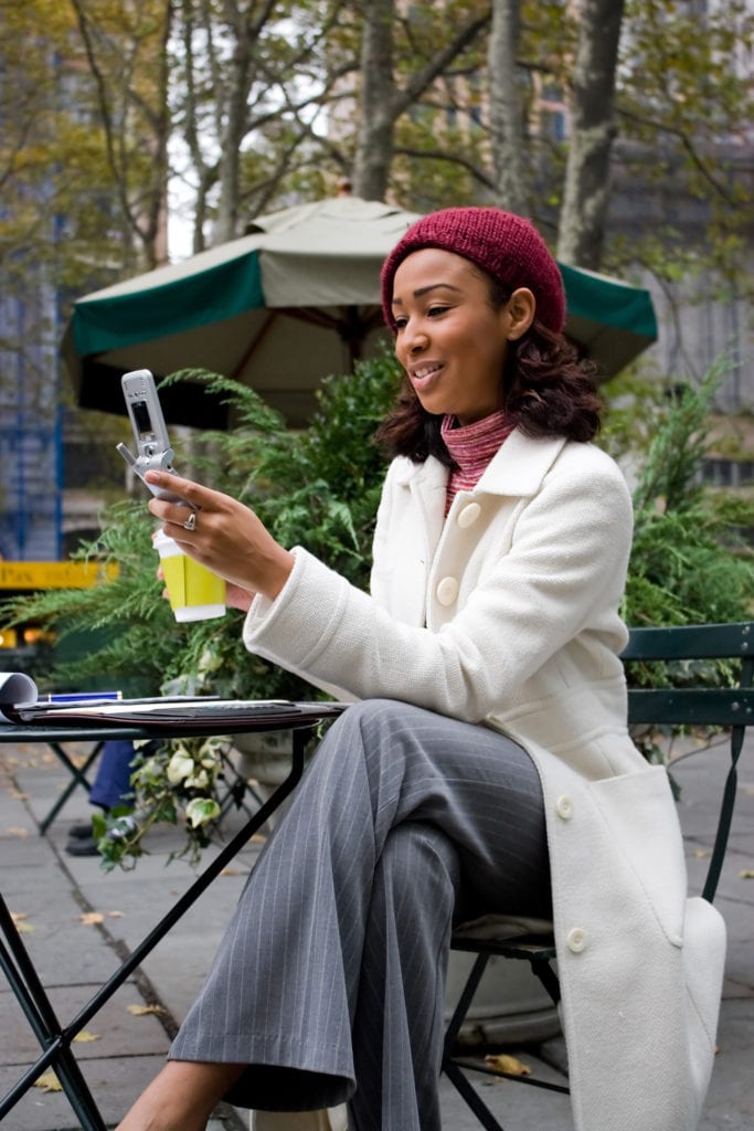 an attractive business woman checking her cell phone in the city she could be text messaging or even browsing the web via wi fi or a 3g connection rtgq1dCBo
