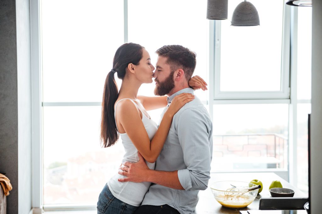 couple cuddling and kiss in kitchen