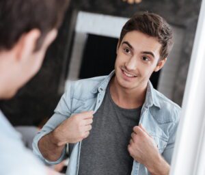 man smiling at himself looking into the mirror