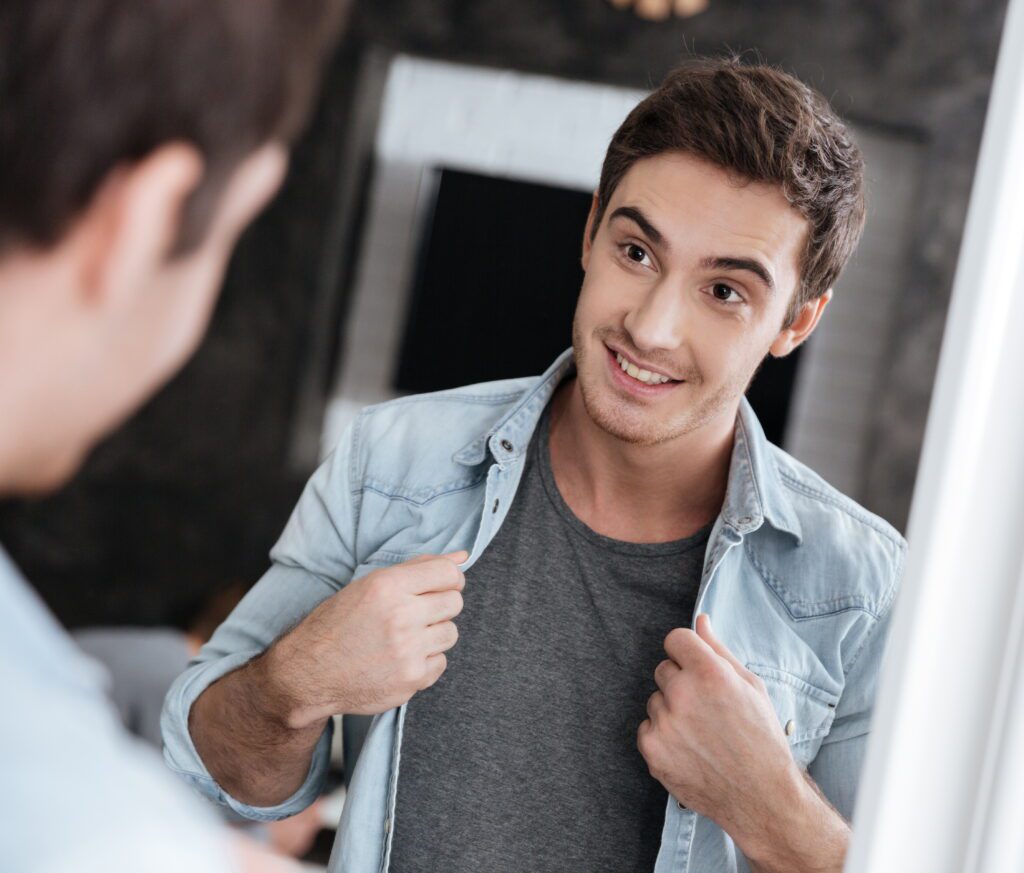 man smiling at himself looking into the mirror scaled