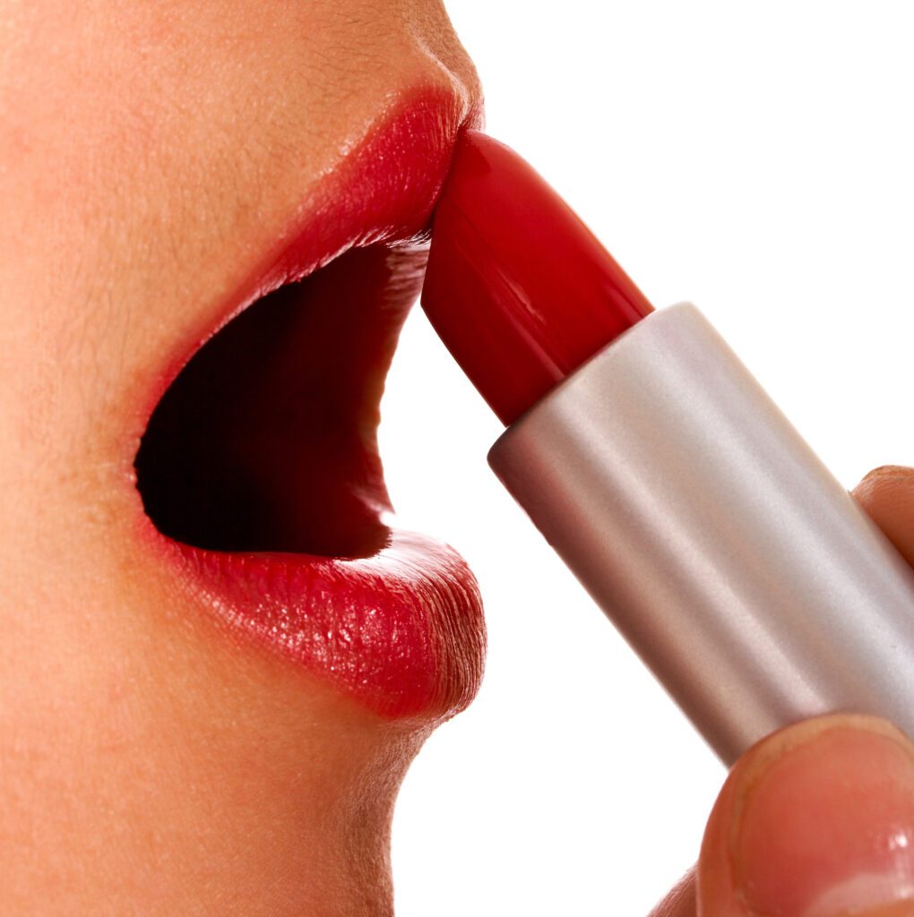 woman applying red lipstick to her lips