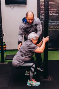 woman doing squats with a personal trainer