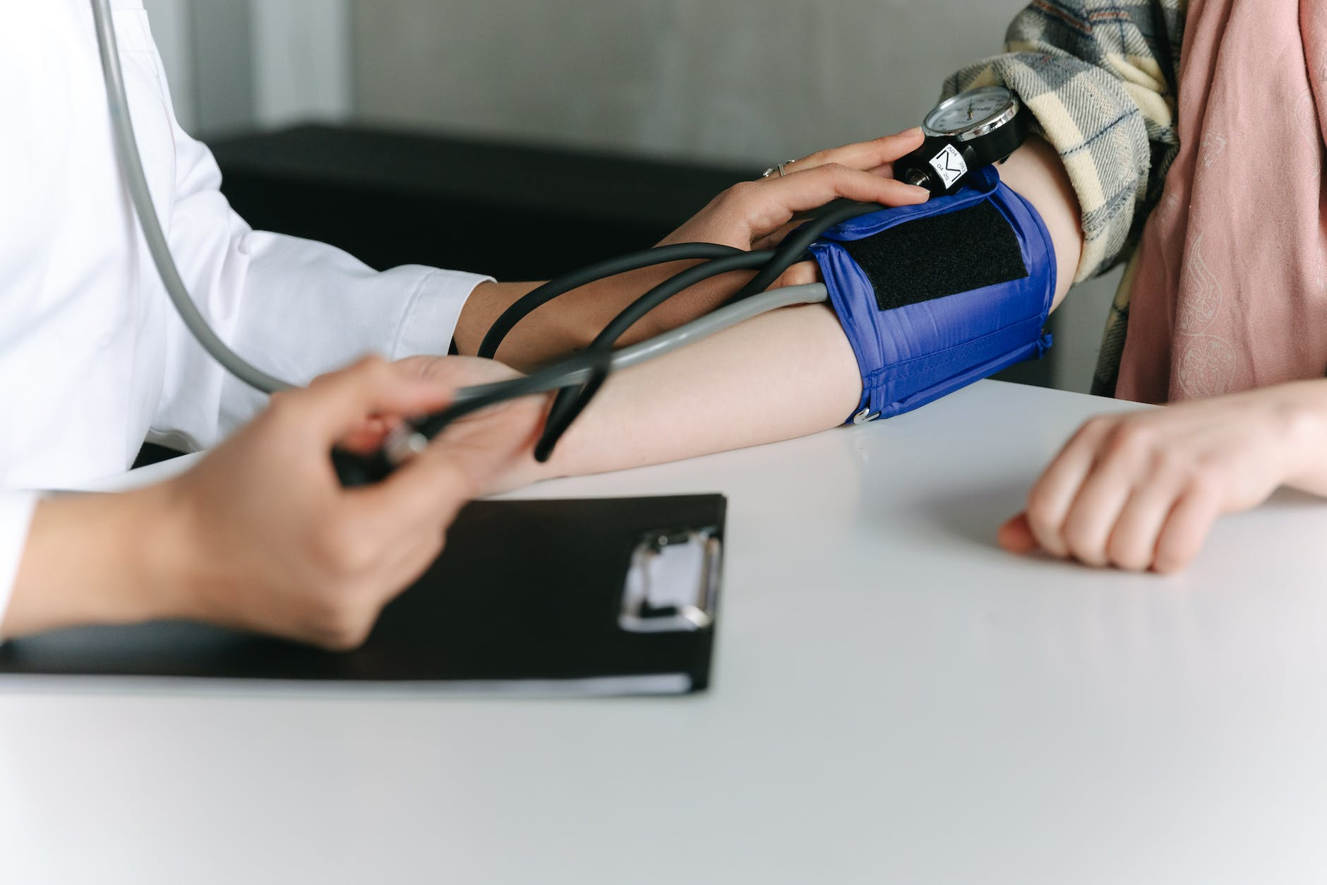 a healthcare worker measuring a patient s blood pressure using a sphygmomanometer