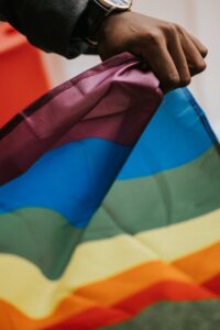 unrecognizable african american guy with pride flag during parade