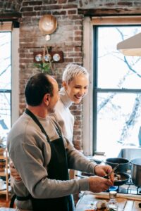 happy couple cooking dinner together in kitchen