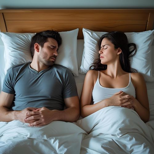 Couple in bed with emotional distance caused by erectile dysfunction due to stress.