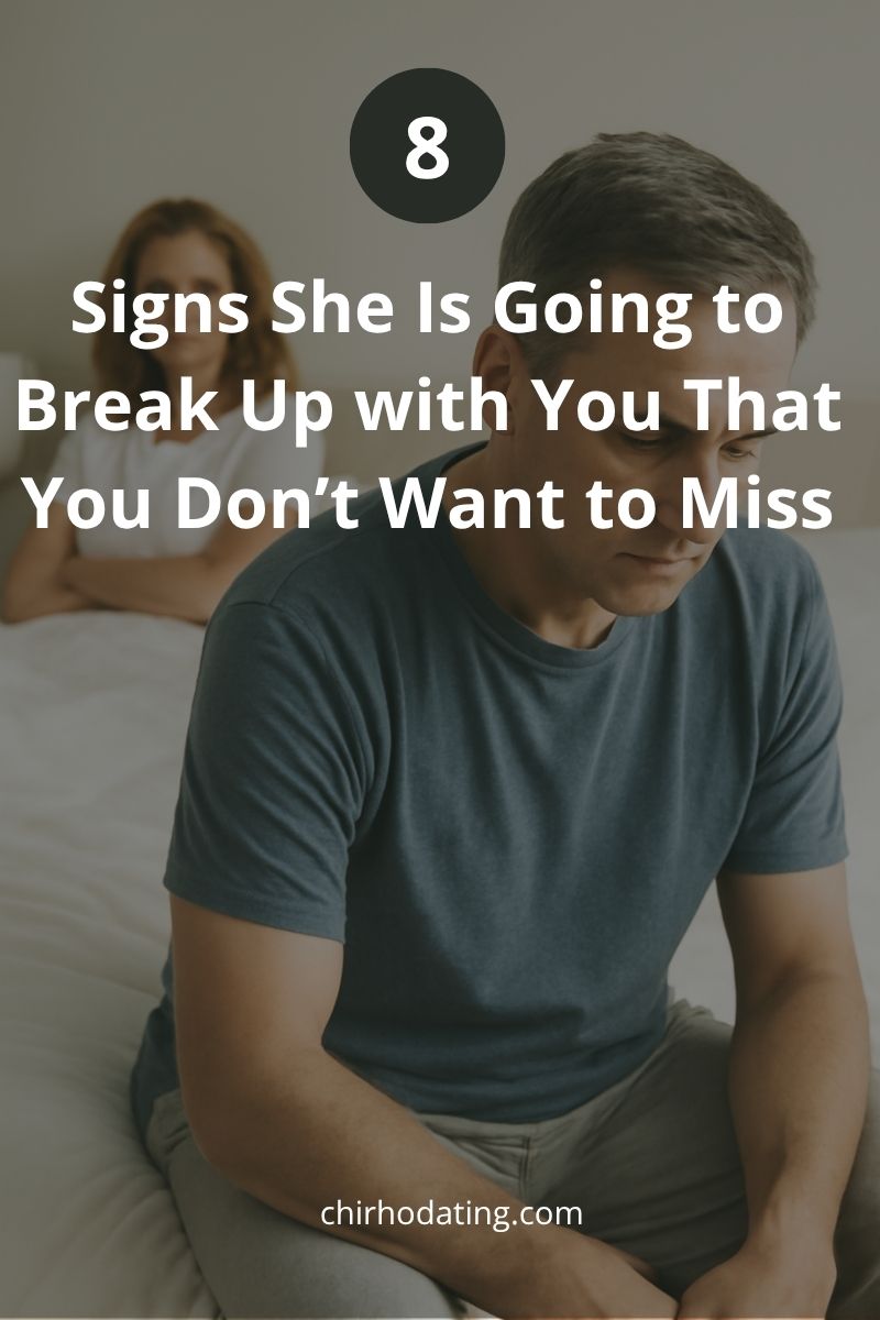 Man sitting on the edge of a bed looking down, while a woman with crossed arms glares at him, illustrating signs she is going to break up with you