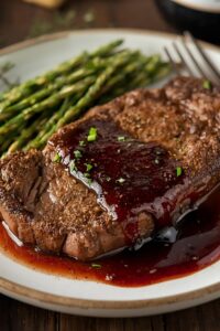 image of herb-crusted steak with red wine reduction,