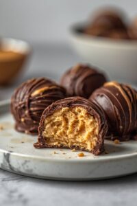 closeup image of chocolate peanut-butter fat bombs served on a plate,