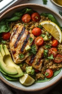 image of a healthy lunch consisting of avocado, chicken, tomatoes, and lemon